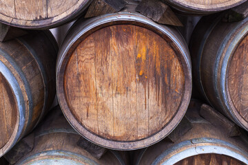 Fototapeta premium Wooden barrels stacked together at a distillery location during the day