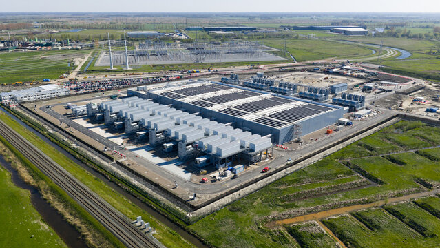 Aerial view of the Datacenter Westpoort facility with cooling systems and industrial infrastructure surrounded by green fields in Groningen, Groningen, Netherlands.