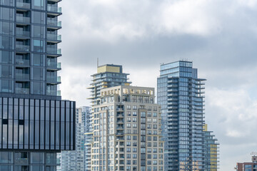 Contemporary high-rise apartment towers with glass facades under cloudy sky © karamysh