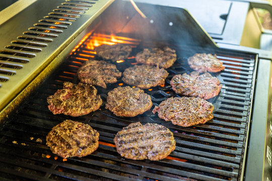 Durchgebratene Burger Hamburger auf einem Grill mit Flammen 