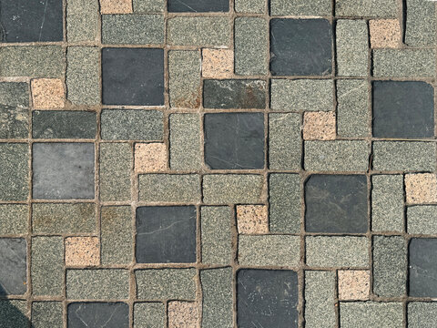 Rectangular outdoor tiles with random shades and roughness. Suitable for exterior garden flooring. Seamless background texture.