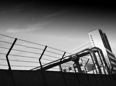 Black and white prison fence with barbed wire