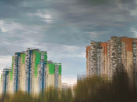 Green and red buildings reflecting in river surface