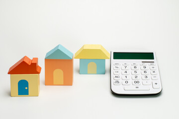 Naklejka premium 積み木の家と電卓で住宅ローンのイメージ