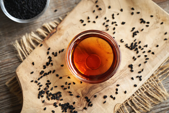 Black cumin or Nigella sativa seed oil in a glass bowl on a table