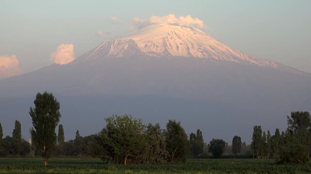 Long distance time lapse view of snowy summit cone of Coropuna stratovolcano peak. Glacier covered shows timelapse clouds, snow volcano, and altiplano edge plus ancient culture.