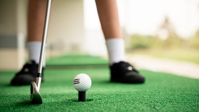 Golf lesson close up of golf ball on tee showing setup precision and preparation before swing at driving range