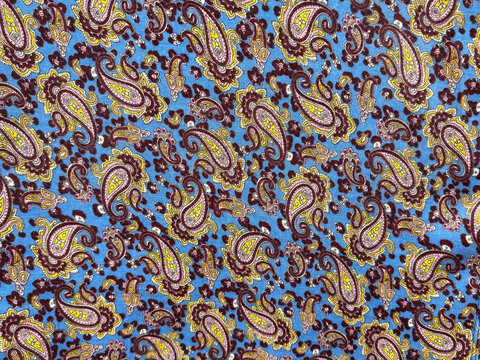 Close up of vintage fabric with random paisley pattern in mix of blue, purple, and brown color. Abstract flower, leaves, foliage, and swirls paisley shape. Seamless background texture