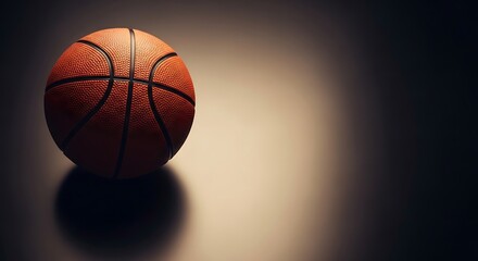 Obraz premium Top view of a single basketball on a dark background with spotlight