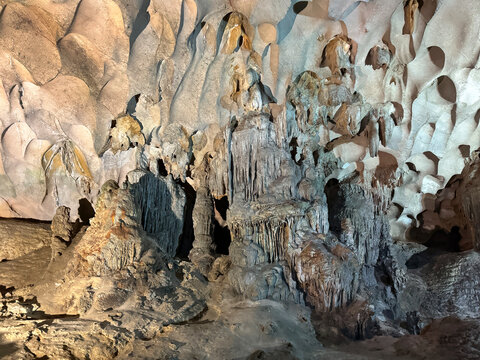 Magnificent cave walls and ceiling texture displaying stalactites and stalagmites with karst and natural limestone rock formations carved by nature.