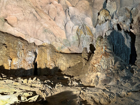 Magnificent cave walls and ceiling texture displaying stalactites and stalagmites with karst and natural limestone rock formations carved by nature.