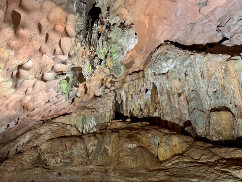 Magnificent cave walls and ceiling texture displaying stalactites and stalagmites with karst and natural limestone rock formations carved by nature.
