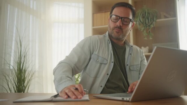 Handsome male freelancer working on computer at home setup