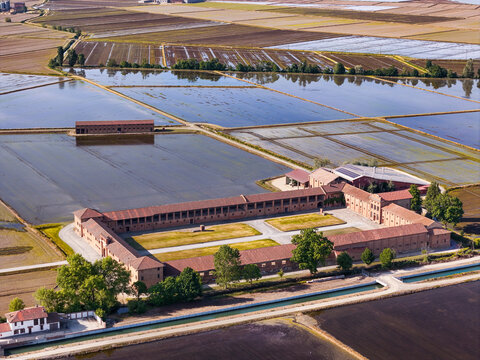 Aerial view of Tenuta Colombara historic farmstead surrounded by flooded rice paddies and rural fields in Livorno Ferraris, Piemonte, Italy.