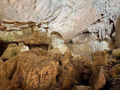 Magnificent cave walls and ceiling texture displaying stalactites and stalagmites with karst and natural limestone rock formations carved by nature.