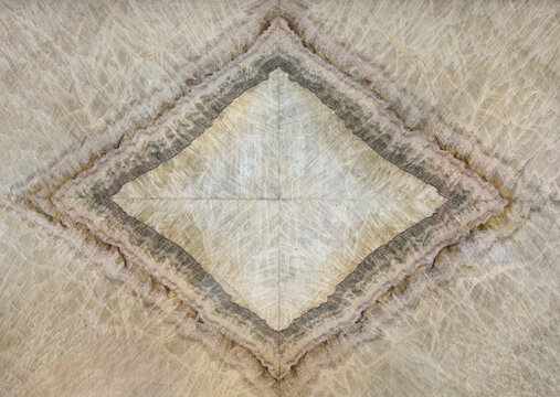 Close up of pen natural brown marble in open book diamond shape pattern. Seamless golden brown marble texture honed and coated. Minerals seamless background texture.