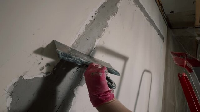 Applying plaster to wall corner with trowel