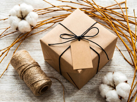 Rustic kraft paper gift box with natural decor and blank tag gift tag mockup