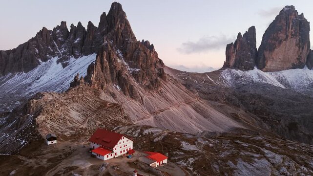 Alpine landscape of Tre Cime mountain peak with mountain hut during autumn in Dolomites, Italy