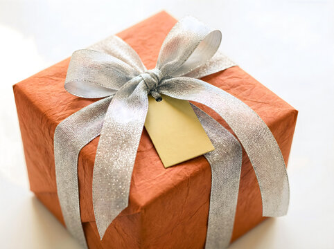 Orange gift box with silver ribbon and tag gift tag mockup