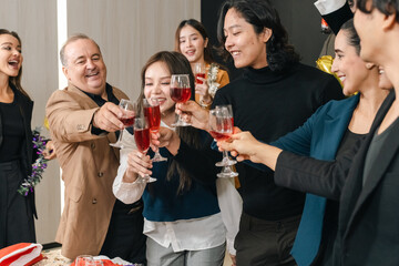 Naklejka premium Celebration group of diverse adult friends toasting with wine glass in indoor party, smiling social gathering with happy people