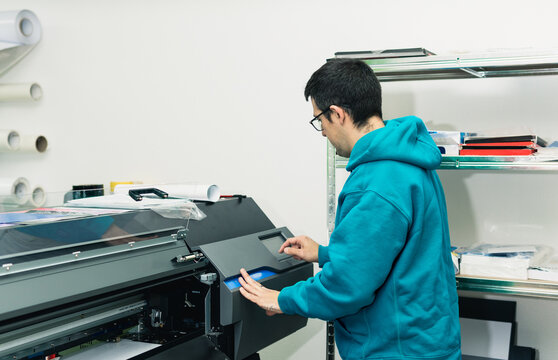 Worker printing on large format digital industrial printer