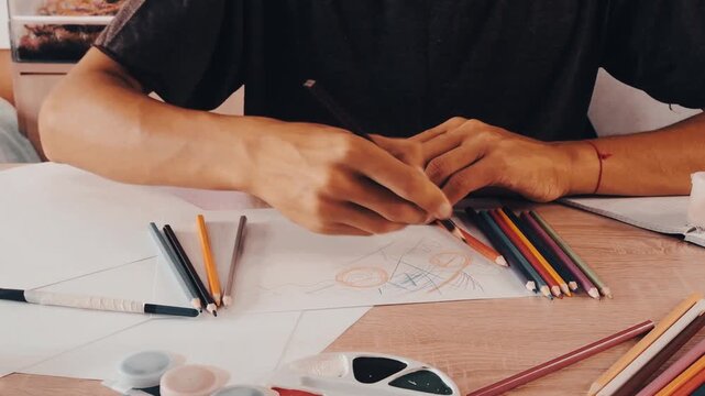 a man draws with pencils on paper 