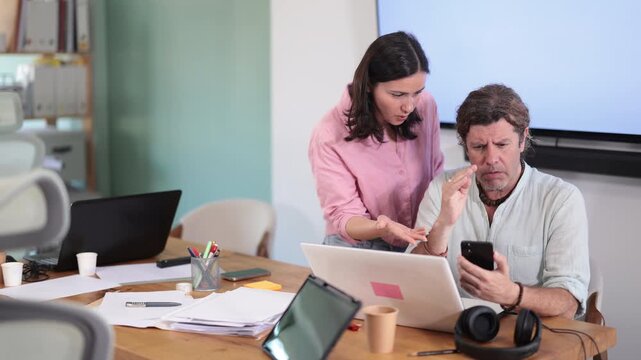 Businesswoman complains to subordinate about her talking on her mobile phone while working in the office. High quality 4k footage