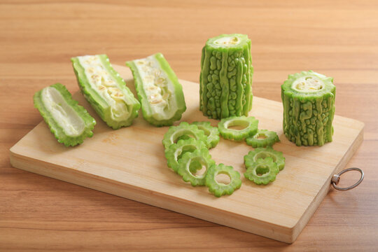 Sliced bitter melon on wooden cutting board