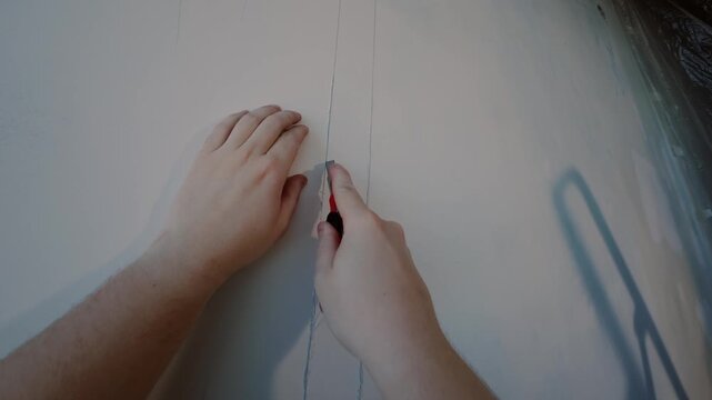Cutting straight line on wall with utility knife