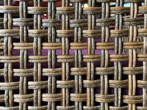 Close up photo of beautiful hand woven synthetic rattan texture in natural brown colors. Wicker art or rattan weaving art pattern in many shapes. Seamless texture.