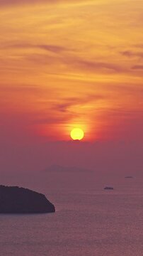 Vertical video. Colorful Sunset over Calm Ocean with Silhouetted Tropical Islands and Soft Clouds Warm Evening Light Scenic Travel Nature Landscape