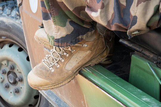 Boots rest on the edge of a military vehicle
