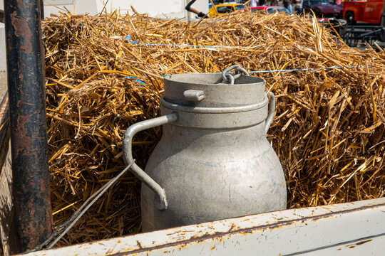 A metal can sits on a cart among straw