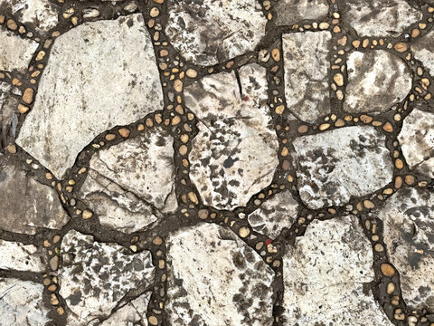 Natural random cut grey flagstone flattened on a surface. Or a series of cobble stones but flattened and paved seamlessly, for floor or wall finishes