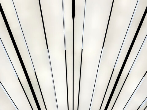 Modern futuristic concept of illuminated panel with sunburst pattern in black and white color. Tilted black and white lines. Ceiling and wall design. Interior design, seamless background texture.