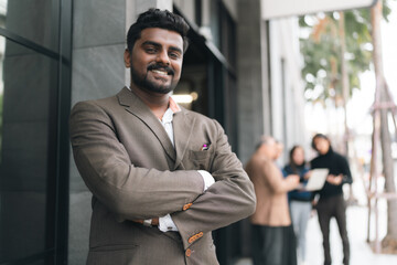 Fototapeta premium Confident man business suit arms crossed standing outside modern building urban background professional smiling adult beard looking at camera