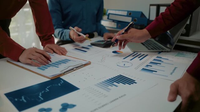 Business team analyzing financial data charts during a collaborative meeting in the office board room