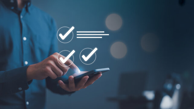 Man checking off completed tasks on mobile phone in a modern digital environment.
