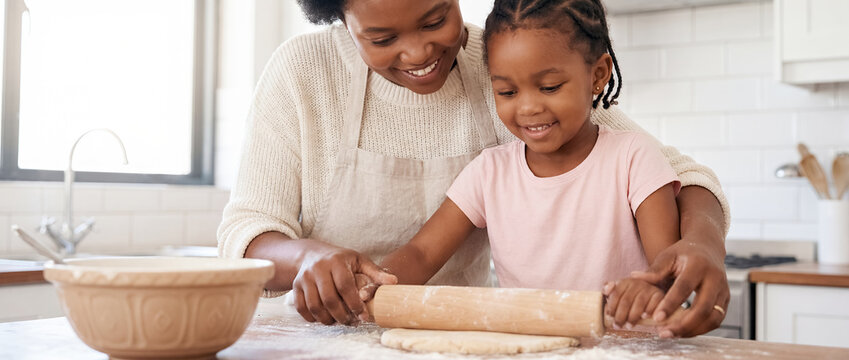 african american mother daughter baking dough kitchen family cooking lesson home bonding fun close up of cheerful black mom teaching little girl to roll pastry on floured counter near sunny window