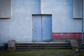 Old double doors on weathered building with stone stairs © Volodymyr