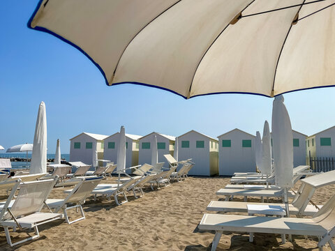 Beach Lounge Chairs and Umbrellas with Coastal Cabins in Lido di Venezia, Italy.