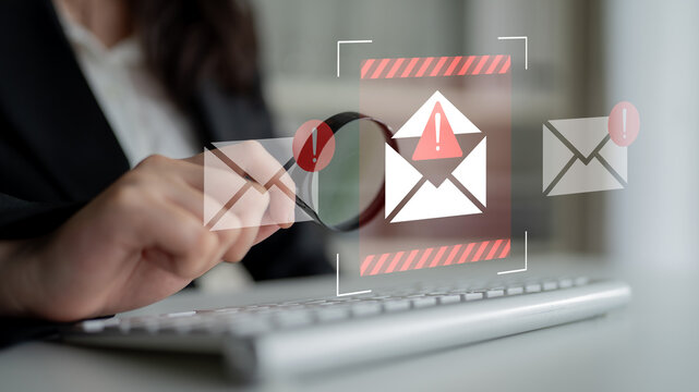 A focused businessperson examines email notifications highlighting alerts and warnings, emphasizing the importance of cybersecurity in a modern office setting. Gantry