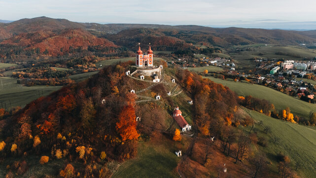Aerial view of the Kalvaria Banska Stiavnica baroque complex on a hill surrounded by vibrant autumn foliage and rolling hills Banska Stiavnica, Banskobystricky kraj, Slovakia.