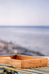 Fototapeta premium Minimal summer composition featuring clean sandy beach with empty copy space for product placement. Rocky coastline meets the sea under bright blue sky, creating natural and scenic atmosphere.