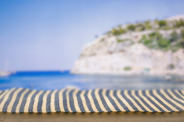 Obraz premium Minimal summer composition featuring clean sandy beach with empty copy space for product placement. Rocky coastline meets the sea under bright blue sky, creating natural and scenic atmosphere.
