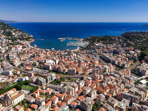 Aerial view of the coastal town of Rapallo featuring the harbor with boats, colorful buildings, and the blue sea under a clear sky Rapallo, Liguria, Italy.