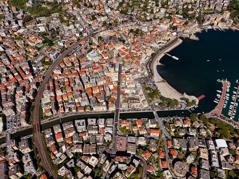 Aerial view of the coastal town of Rapallo featuring colorful buildings, a sandy beach, and a marina filled with boats along the Ligurian coast in Rapallo, Liguria, Italy.