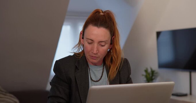 Focused on the Task: A concentrated individual, engrossed in a laptop at home, demonstrates the focus required in a working setting.