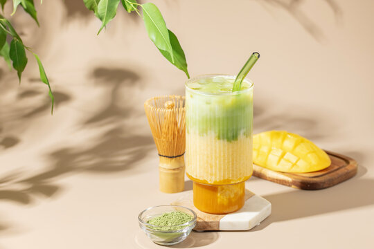 Iced mango matcha latte in glass on the table